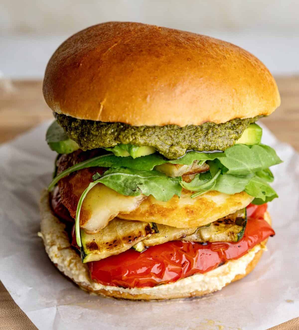 A stacked burger featuring YAMAS! halloumi, roast peppers, courgette, pesto mayo and salad